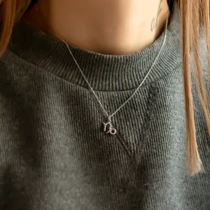 Gold diamond CAPRICORN pendant worn on the neck