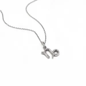 Gold diamond CAPRICORN pendant lying flat with chain