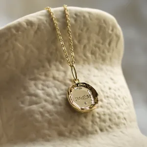 Close-up of the COLETTE gold pendant with M&M engraving and diamond