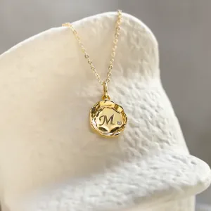 COLETTE gold pendant with engraved M and diamond in a close-up view
