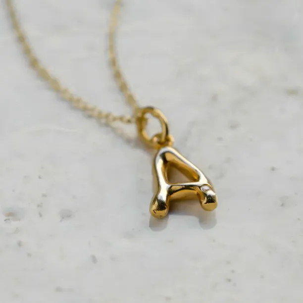 Close-up of the gold letter A pendant with diamond