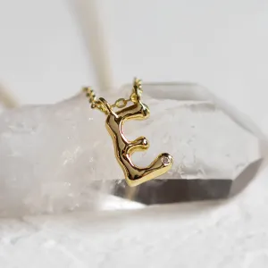 Close-up of a gold letter C pendant with diamond