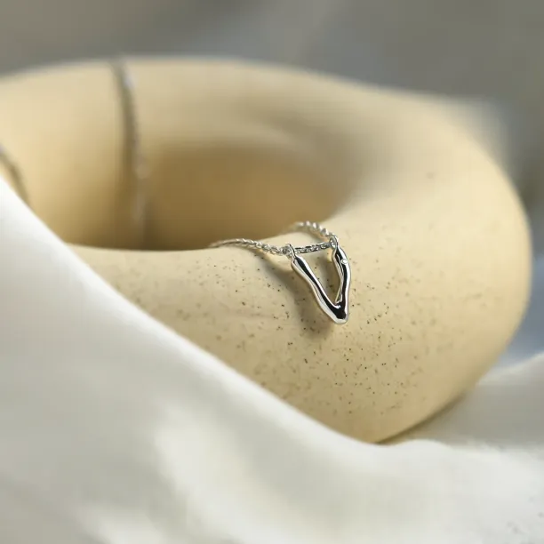 Angled view of a letter V pendant with diamond