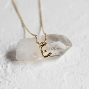 Close-up of a gold letter E pendant with a diamond on a chain