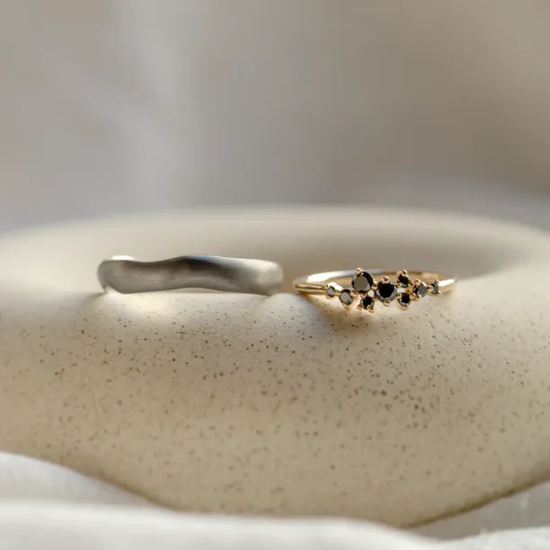 DUE wedding rings separated to show the black rhodium band and diamond ring