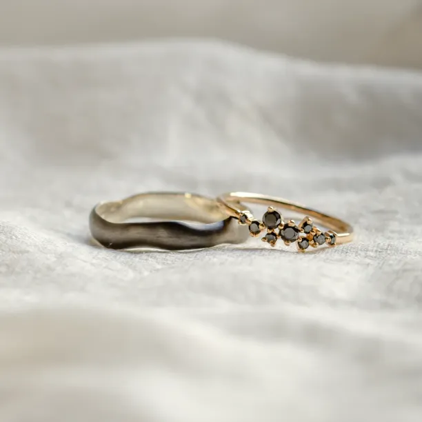 Close-up of DUE black rhodium and black diamond wedding rings together