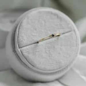 SABINE sapphire and diamond ring displayed on a jewelry cushion