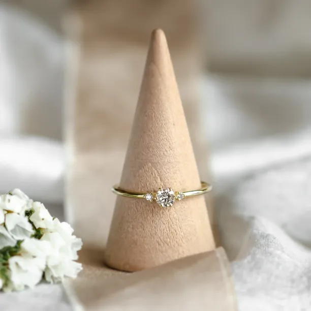 ALICIA gold engagement ring with diamonds displayed on a ring cone