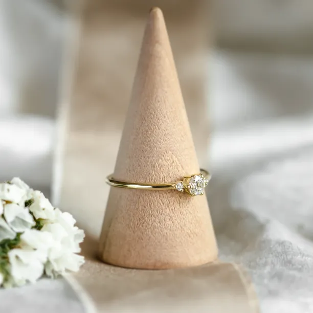 ALICIA gold engagement ring with diamonds, angled view on a ring cone