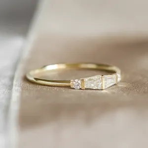 Close-up angled view of LUMI gold ring with baguette and round moissanites