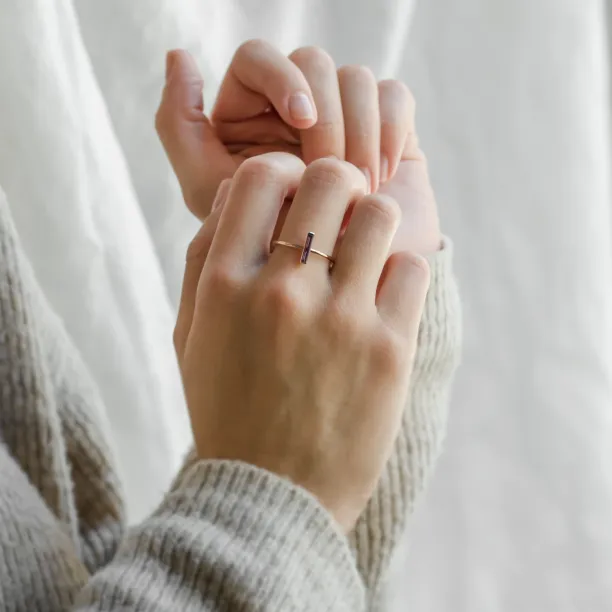 NYX gold ring with baguette amethyst worn on a hand