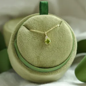 Gold peridot and diamond pendant with chain, close-up
