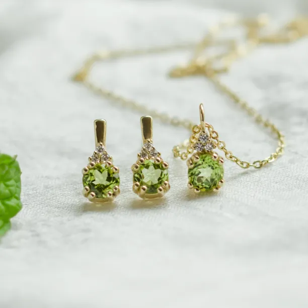Close-up of the gold peridot and diamond pendant with matching earrings