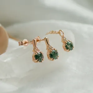 Angled close-up of gold TIA earrings with moss agate and diamonds