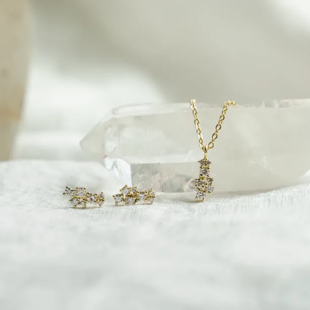 ELIN diamond cluster earrings displayed with a matching pendant