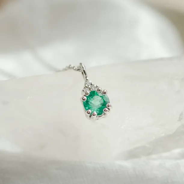 Close-up of the emerald and diamond pendant from the ELANNA set
