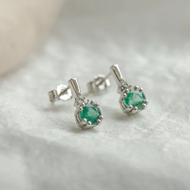 Angled view of LENNY gold earrings with emeralds and diamonds