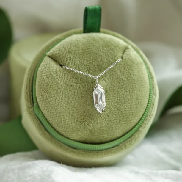 Zlatý přívěsek s hexagon moissanitem FINA vystavený na šperkovém polštářku