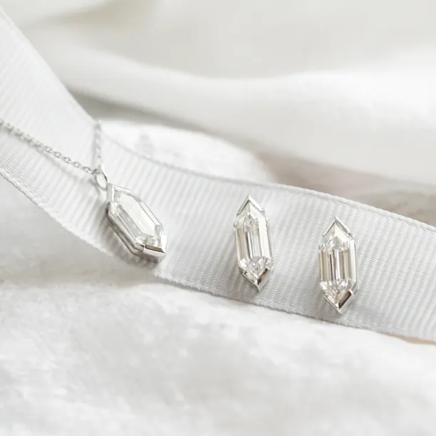 Close-up of SERENA moissanite earrings and a matching necklace pendant