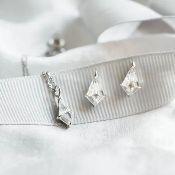 Pair of DANE gold kite moissanite earrings in close-up