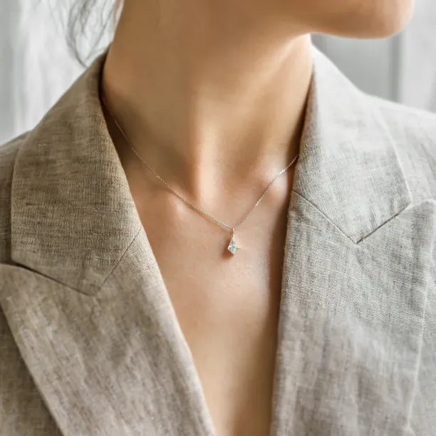 Gold DIONA pendant with kite-shaped moissanite worn on the neck