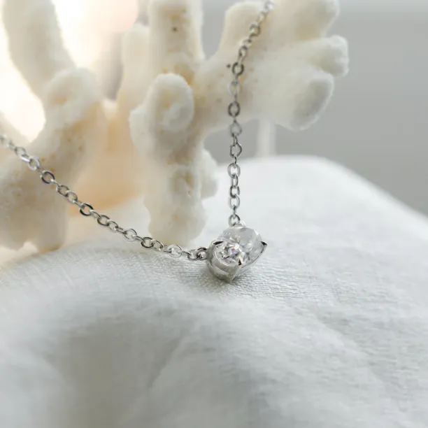 Šikmý detail přívěsku zlatého náhrdelníku s oválným laboratorním diamantem