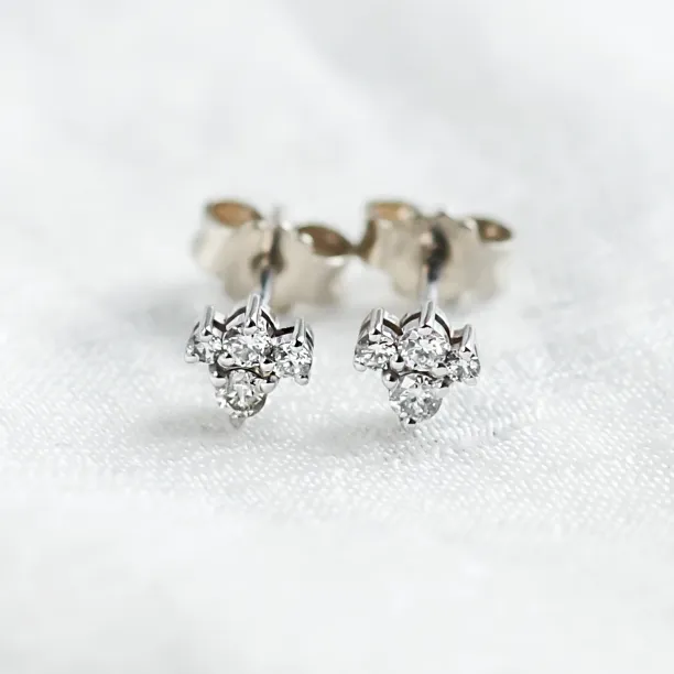 Close-up of gold diamond cluster earrings with butterfly backs