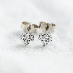 Close-up of gold diamond cluster earrings with butterfly backs