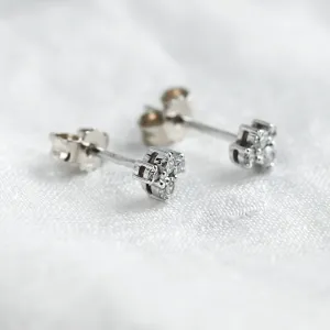 Angled view of gold diamond cluster earrings showing the posts and backs