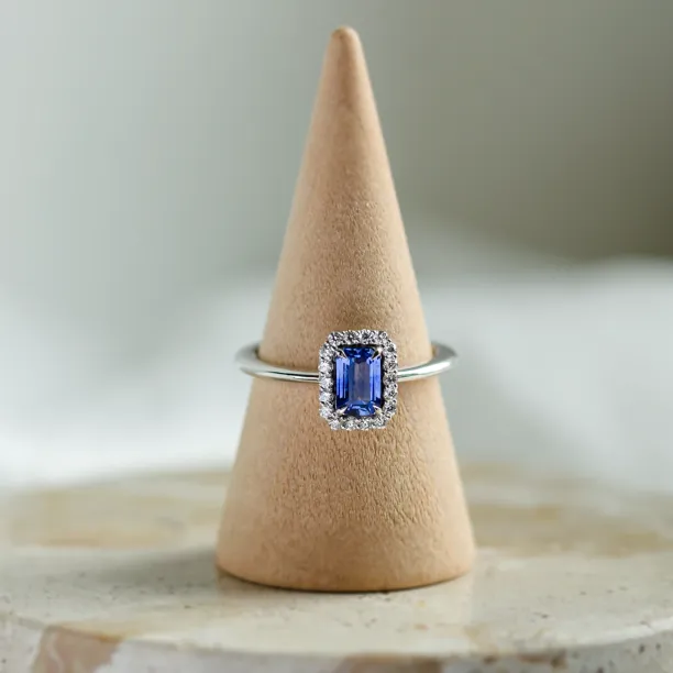 Angled view of LEAR engagement ring with teal sapphire and diamond halo