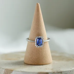 Angled view of LEAR engagement ring with teal sapphire and diamond halo