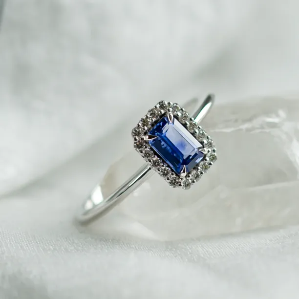Close-up of LEAR engagement ring with teal sapphire and diamond halo