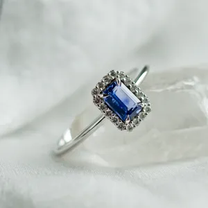 Close-up of LEAR engagement ring with teal sapphire and diamond halo