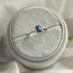 Angled view of LEAR engagement ring with teal sapphire and diamond halo