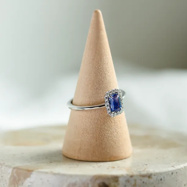 LEAR engagement ring with a baguette teal sapphire and diamond halo, angled view