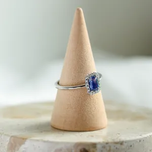 LEAR engagement ring with a baguette teal sapphire and diamond halo, angled view