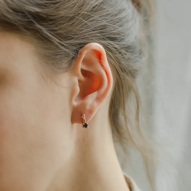 SEAN stud earring with a black diamond and twig detail, worn on the ear