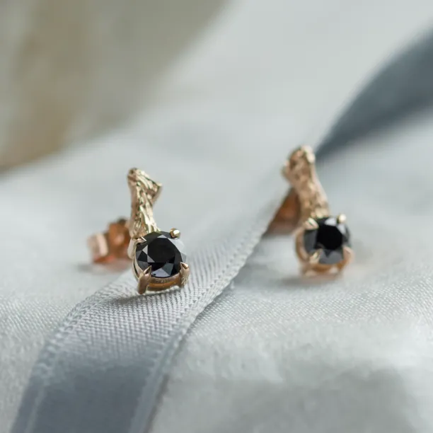 Close-up angled view of SEAN stud earrings with black diamonds and twig details