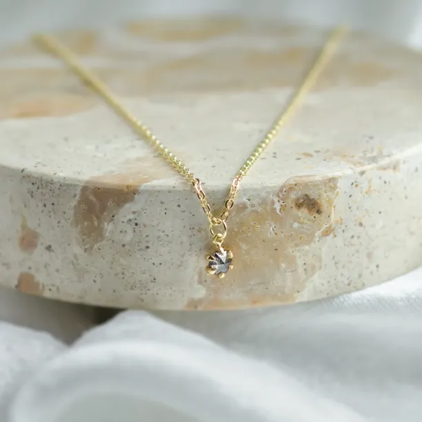 CADIE gold pendant with salt and pepper diamond in a centered close-up
