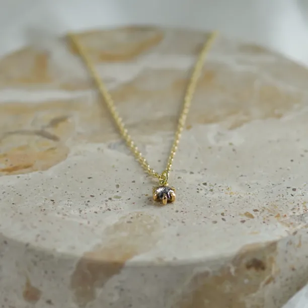Angled close-up of the CADIE gold pendant with salt and pepper diamond