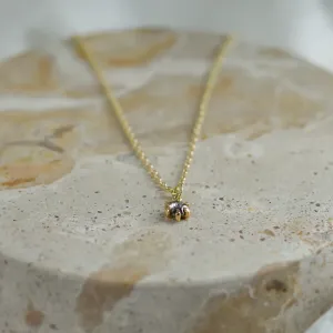 Angled close-up of the CADIE gold pendant with salt and pepper diamond