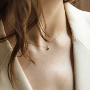 Gold SAND pendant necklace worn on the neck with a salt and pepper diamond