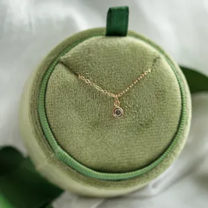 Full view of the gold SAND necklace with its bezel-set diamond pendant