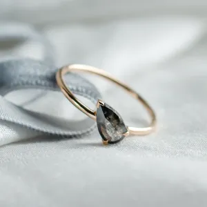 Close-up of the pear-shaped salt and pepper diamond on ALIA ring
