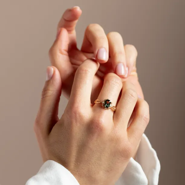 BAROQUE gold ring with green sapphire and diamonds worn on the hand