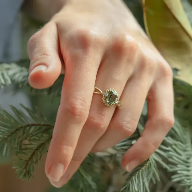 BAROQUE gold ring with green sapphire and diamonds worn on a hand