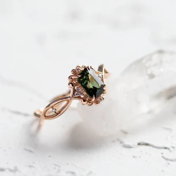 Close-up angled view of the BAROQUE gold ring with green sapphire and diamonds