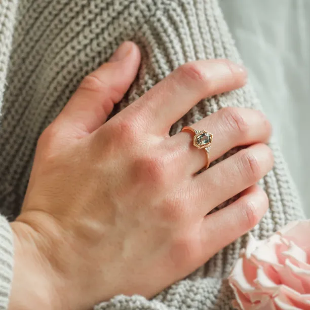 Gold vintage ring with a hexagon sapphire and diamonds worn on a hand