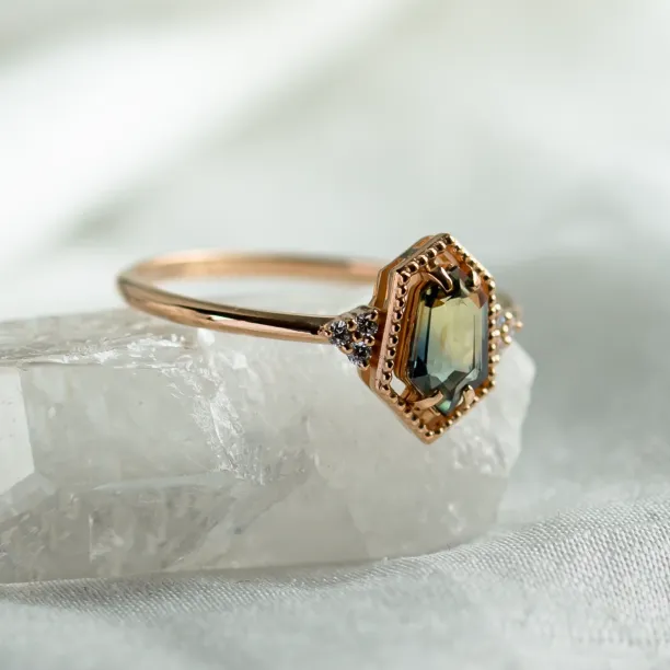 Angled close-up of the gold ring with a hexagon sapphire and diamonds