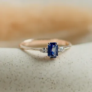 Detailní čelní pohled na zlatý prsten LEILANI s emerald safírem a bočními diamanty